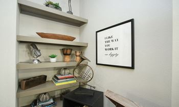 a home office with a framed quote on the wall and a fan